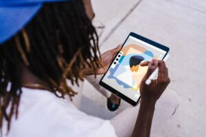 Person with locs drawing on a mobile tablet
